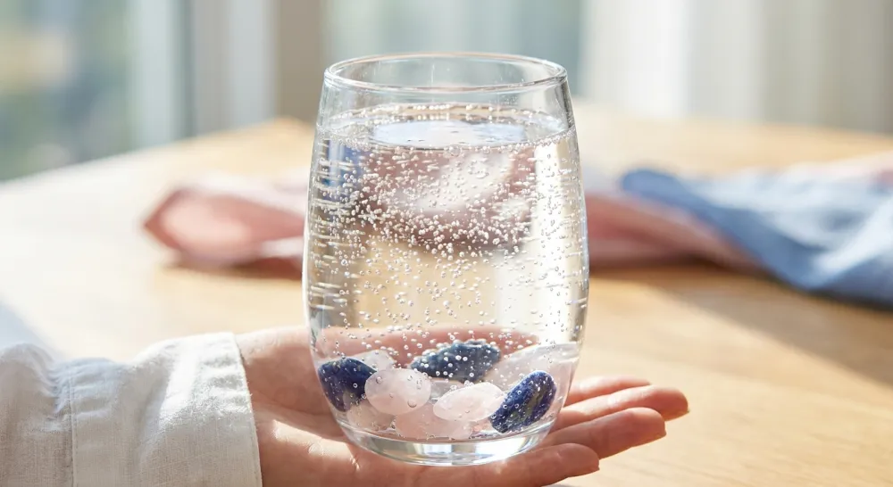 Glas bruisend helder water met bosbessen