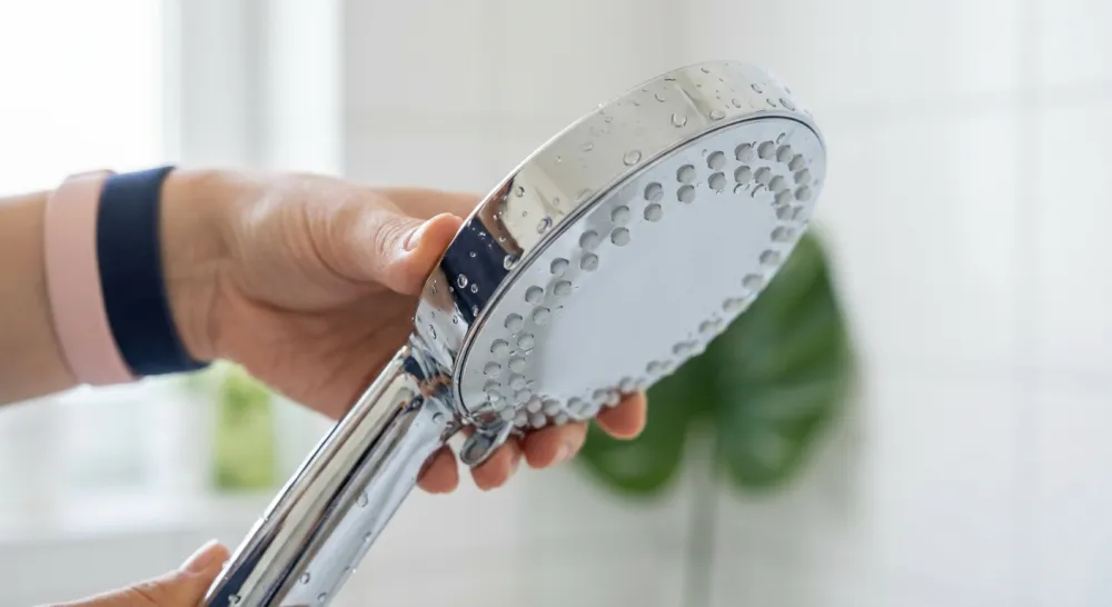 Close-up van een schone chromen douchekop met vrije sproeigaatjes